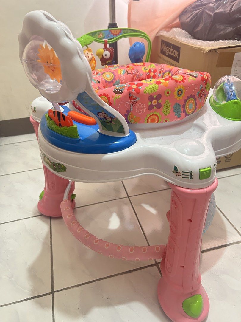Baby Company Walker and activity center (Category: Infant Playtime) located in Manila. Submitted by zarah_maricar (Listing ID 1435013385, Image 1). Description: Selling our pre-loved walker with activity center. Features a rotating sun toy, hanging animal toys, and a padded seat. Includes lights and music. The walker has a pink and white color scheme with a floral seat pattern. It has a sturdy base with pink legs and a safety bar. Flaw/issue: lig
