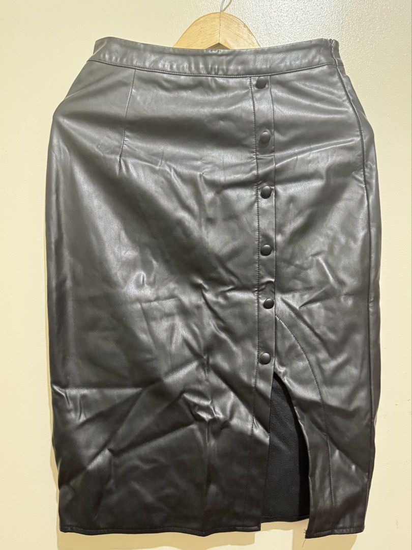 Black Faux Leather Button-Up Skirt (Category: Skirts) located in Mandaluyong City. Submitted by riaria03 (Listing ID 1435073015, Image 1). Description: - Black faux leather skirt - Button-up design - Features a front slit - High-waisted fit - Pencil skirt silhouette - Perfect for a chic and versatile look - Easy to pair with different tops and shoes 📍Please note that actual colors may slightly vary due to lighting and camera effects..