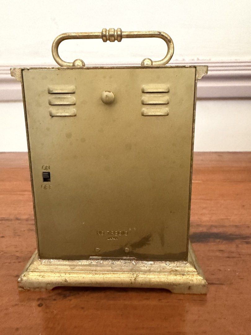 Bulova Vintage Travel Clock (Category: Clocks) located in Las Pinas. Submitted by mightybird.a4339c (Listing ID 1434997573, Image 2). Description: - Vintage Bulova travel clock - Gold-colored finish - Roman numeral hour markers - Convenient carrying handle - On/off switch - Marked "Japan" - Visible clock mechanism.