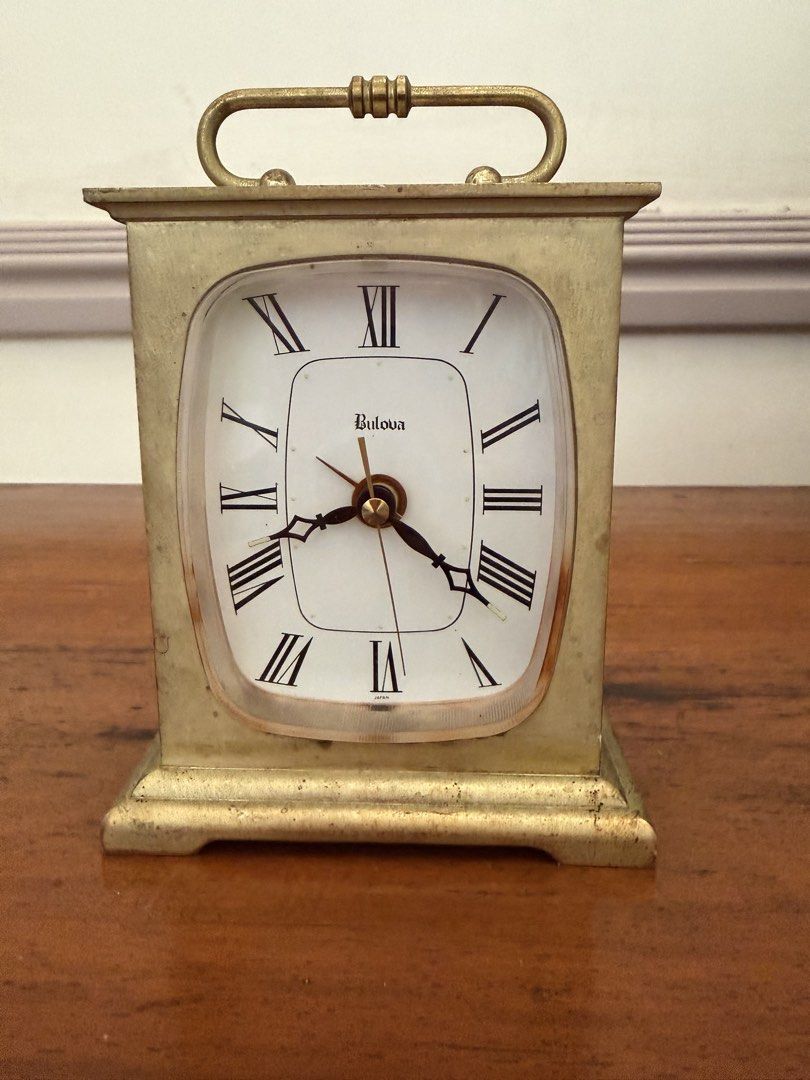 Bulova Vintage Travel Clock (Category: Clocks) located in Las Pinas. Submitted by mightybird.a4339c (Listing ID 1434997573, Image 1). Description: - Vintage Bulova travel clock - Gold-colored finish - Roman numeral hour markers - Convenient carrying handle - On/off switch - Marked "Japan" - Visible clock mechanism.