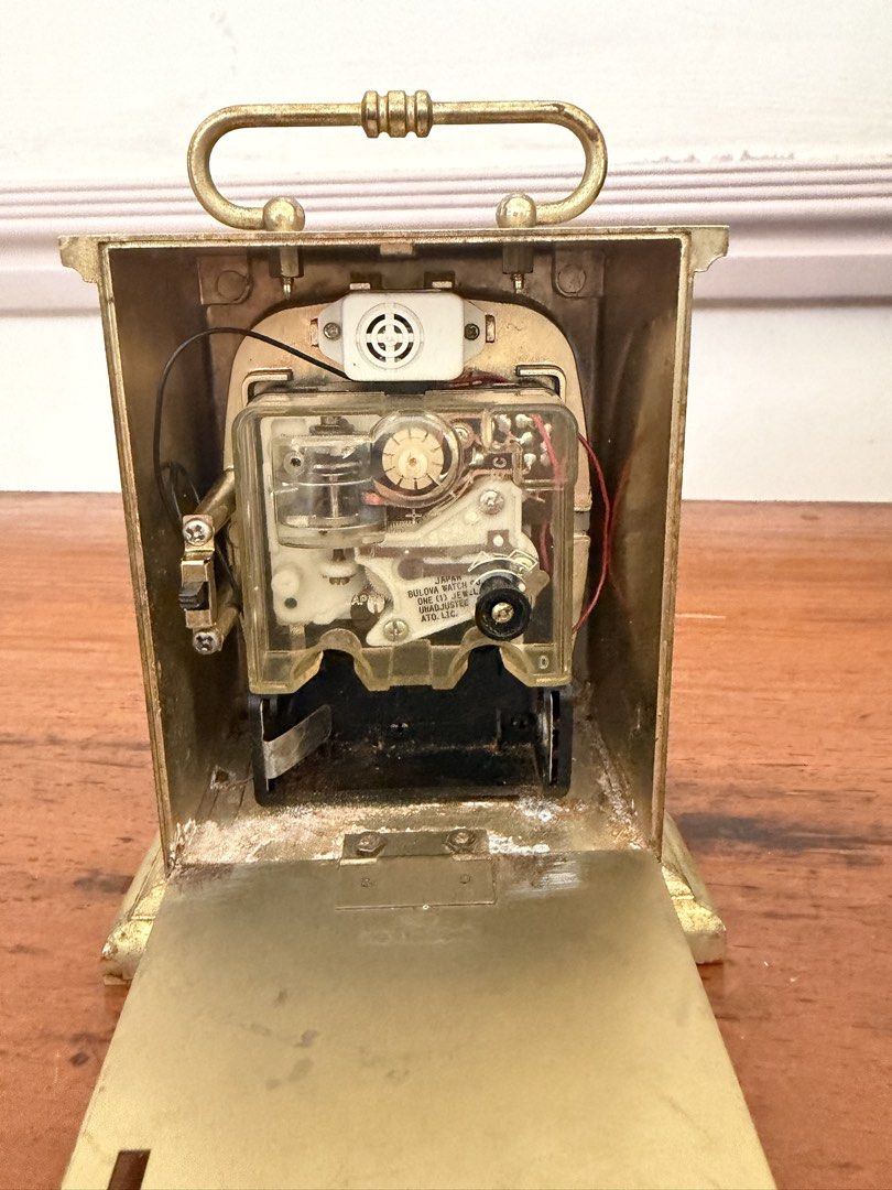 Bulova Vintage Travel Clock (Category: Clocks) located in Las Pinas. Submitted by mightybird.a4339c (Listing ID 1434997573, Image 3). Description: - Vintage Bulova travel clock - Gold-colored finish - Roman numeral hour markers - Convenient carrying handle - On/off switch - Marked "Japan" - Visible clock mechanism.