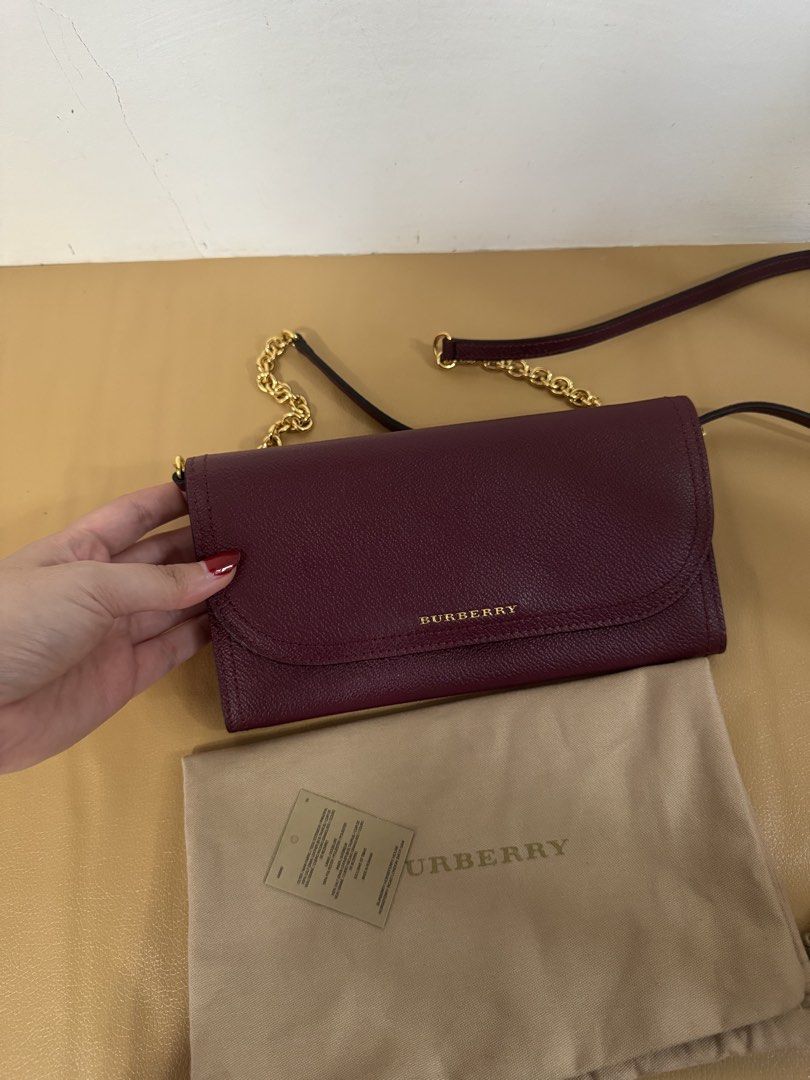 Burberry Wallet on Chain (Category: Luxury Bags & Wallets) located in Malolos. Submitted by ebc17 (Listing ID 1435019879, Image 2). Description: - Burgundy Burberry wallet on chain - Gold-tone hardware - Chain strap - Flap closure - Includes dust bag - Multiple compartments for cards and cash - Textured leather exterior - Subtle Burberry logo.