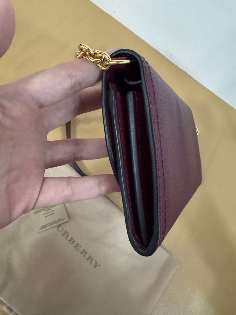 Burberry Wallet on Chain (Category: Luxury Bags & Wallets) located in Malolos. Submitted by ebc17 (Listing ID 1435019879, Image 3). Description: - Burgundy Burberry wallet on chain - Gold-tone hardware - Chain strap - Flap closure - Includes dust bag - Multiple compartments for cards and cash - Textured leather exterior - Subtle Burberry logo.