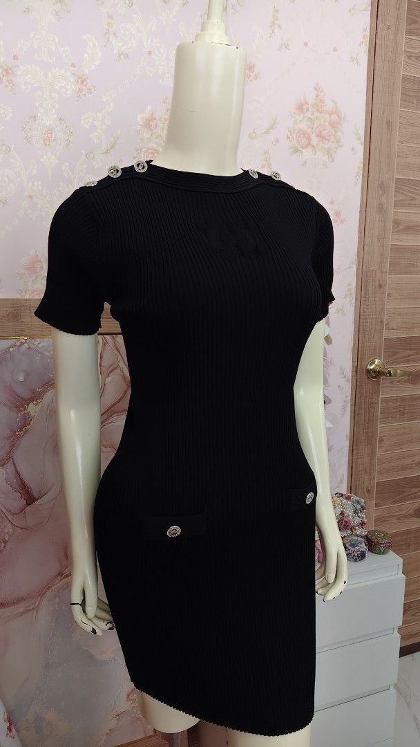 Chanel Black Knit Dress (Category: Luxury Apparel) located in Pagudpud. Submitted by altheacee063978 (Listing ID 1435123466, Image 2). Description: -fits s-m - Black knit dress - Short sleeves - Fitted silhouette - Decorative buttons on shoulders and pockets - Ribbed texture - Sophisticated design.
