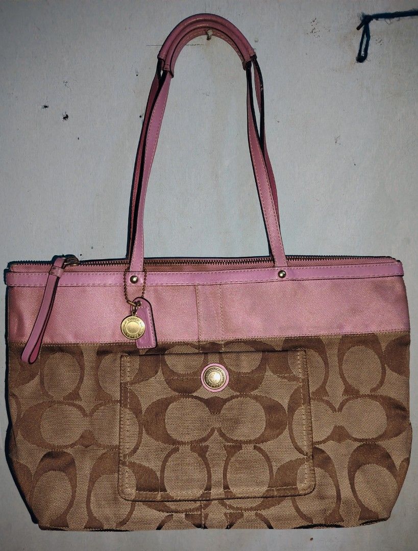 Coach Pink and Brown Tote Bag (Category: Luxury Bags & Wallets) located in Manila. Submitted by freestone-5d55 (Listing ID 1435107885, Image 1). Description: - Coach tote bag - Pink and brown color - Signature Coach pattern - Front pocket with button closure - Top zip closure - Pink interior - Multiple pockets - Coach label.