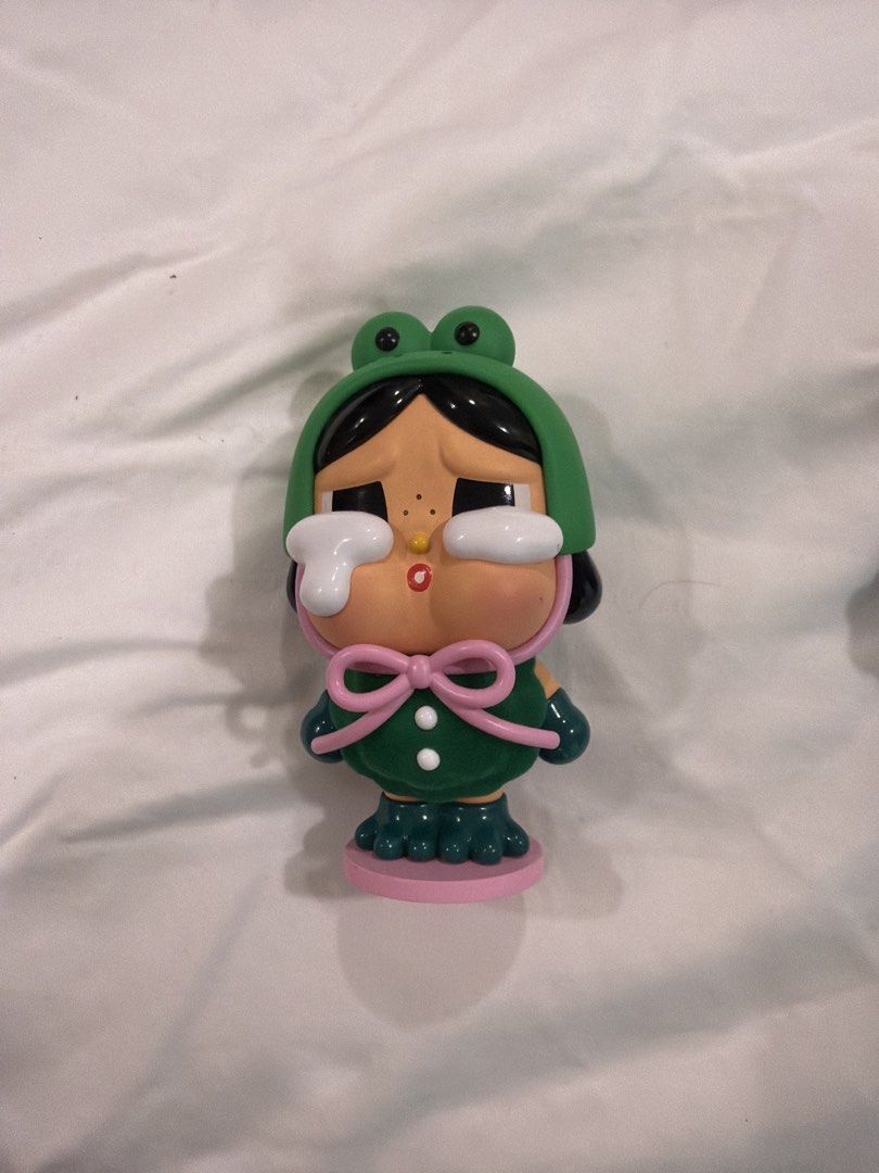 Cute Frog Girl Figurine (Category: Figurines & Statues) located in Makati City. Submitted by _saleph_ (Listing ID 1435079443, Image 1). Description: - Adorable figurine of a girl. - Wearing a frog hat and outfit. - Features a sad expression with tears. - Pink bow and pink base. - Green outfit with white buttons. - Black hair and small nose..