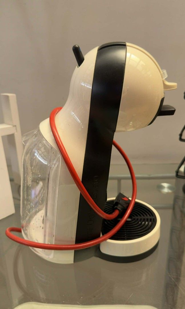 Dolce Gusto Coffee Machine + Capsule stand (Category: Coffee Machines & Makers) located in Manila. Submitted by gentlefire.1f0e1d (Listing ID 1435029301, Image 3). Description: - Dolce Gusto coffee machine - Color: Black and cream - Features: Water reservoir, drip tray - Red cord - Black accent - In good working condition.