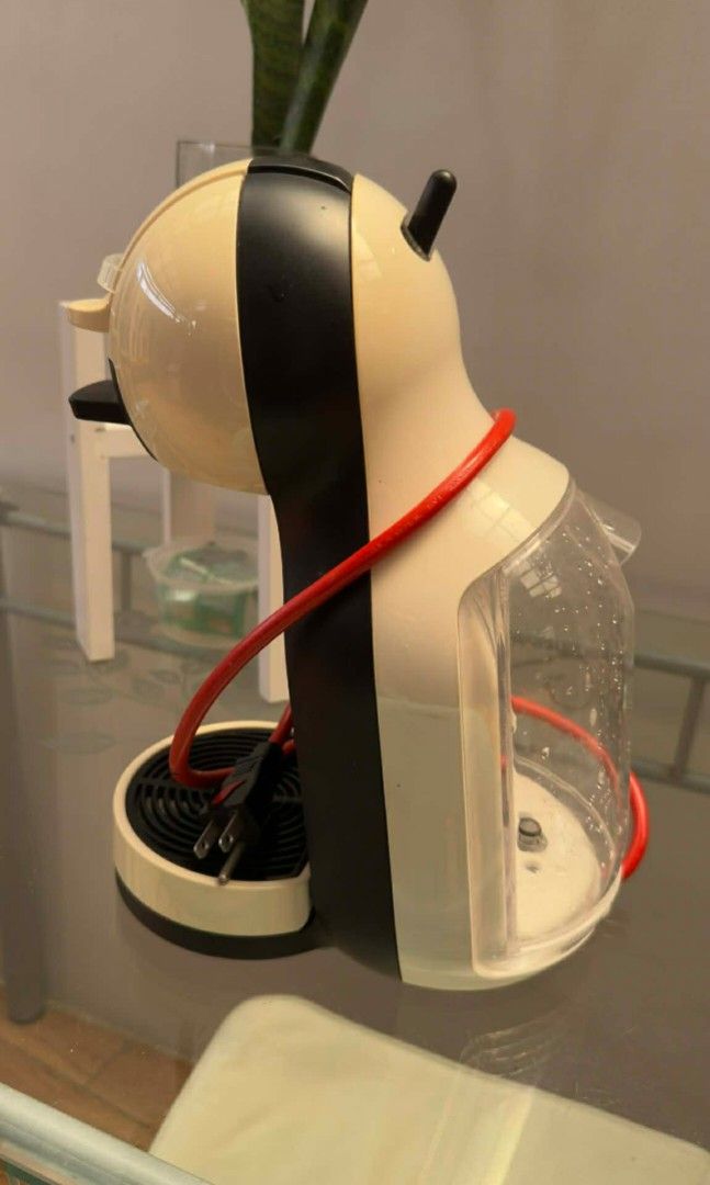 Dolce Gusto Coffee Machine + Capsule stand (Category: Coffee Machines & Makers) located in Manila. Submitted by gentlefire.1f0e1d (Listing ID 1435029301, Image 2). Description: - Dolce Gusto coffee machine - Color: Black and cream - Features: Water reservoir, drip tray - Red cord - Black accent - In good working condition.