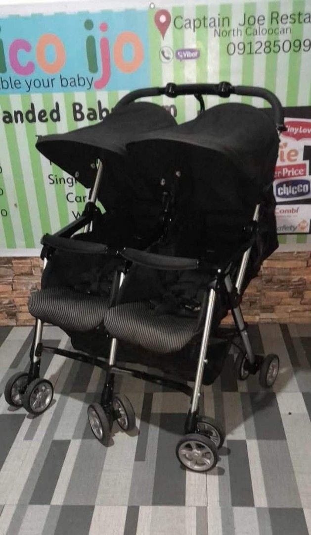 Double Stroller (Category: Strollers) located in Caloocan City. Submitted by Unicoijo02 (Listing ID 1435062669, Image 3). Description: - Black double stroller - Two seats with canopies - Foldable design - Multiple wheels for stability - Curved handle for comfortable pushing.