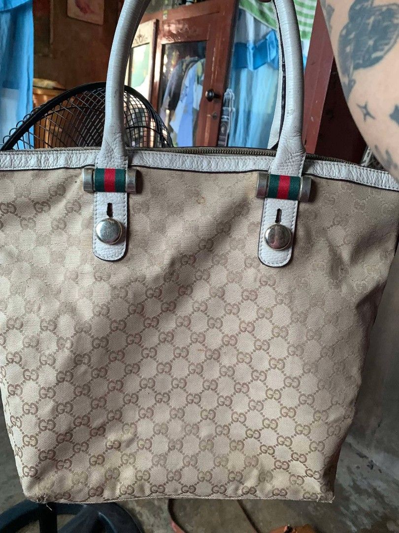 Gucci GG Canvas Tote Bag (Category: Luxury Bags & Wallets) located in Tarlac. Submitted by jaesii00 (Listing ID 1435141319, Image 1). Description: - Gucci tote bag - Iconic GG canvas pattern - Beige exterior with white leather trim - Zipper closure - Spacious interior with brown lining - Includes leather tag with Gucci logo and "Made in Italy" - Serial number tag -issue scratch sa ilalim.