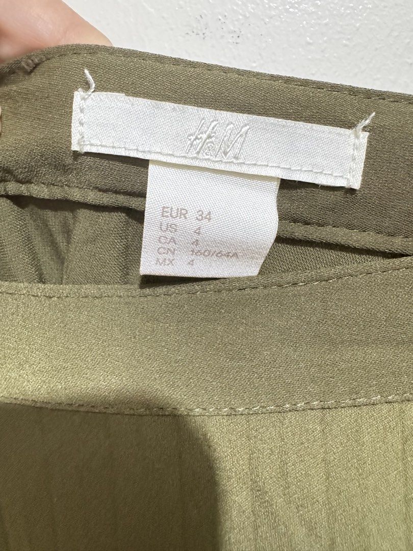 H&M Olive Green Maxi Skirt (Category: Skirts) located in Mandaluyong City. Submitted by riaria03 (Listing ID 1435077236, Image 2). Description: - Olive green maxi skirt - High-waisted design - Flowing A-line silhouette - Made of smooth, lightweight fabric - Solid color, no patterns - Suitable for casual and semi-formal occasions 📍Please note that actual colors may slightly vary due to lighting and camera effects. ✅ Items are either preloved or b