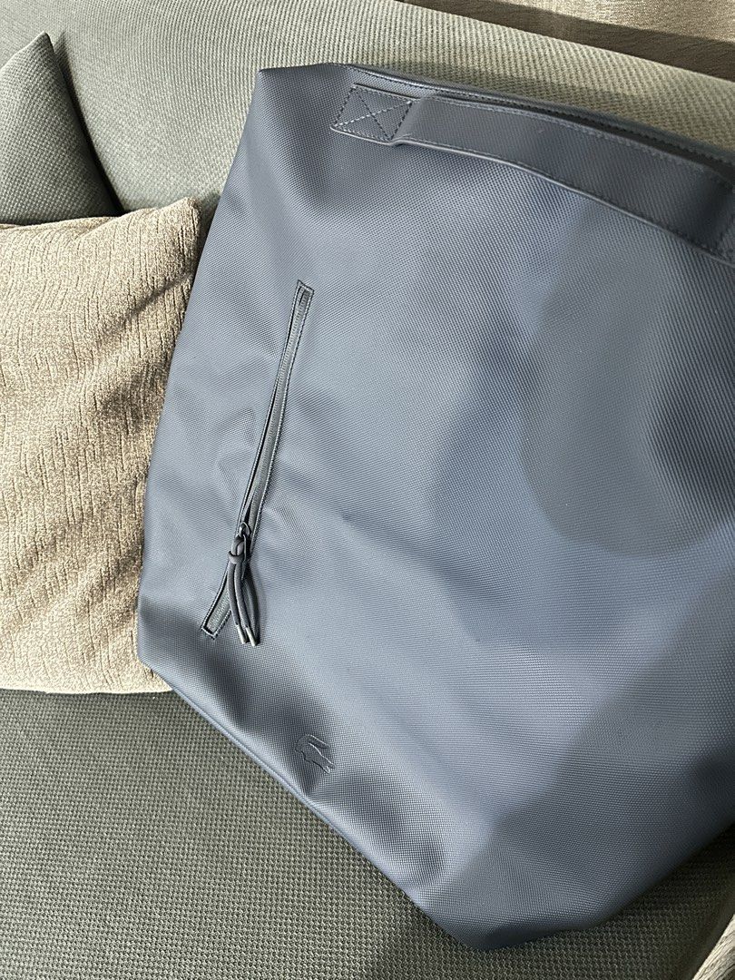 Lacoste Tote backpack/bag (Category: Backpacks) located in Quezon City. Submitted by camille96 (Listing ID 1435154954, Image 1). Description: - Lacoste tote bag - Front zipper pocket - Top handle and shoulder straps - Features the Lacoste logo - Solid color.
