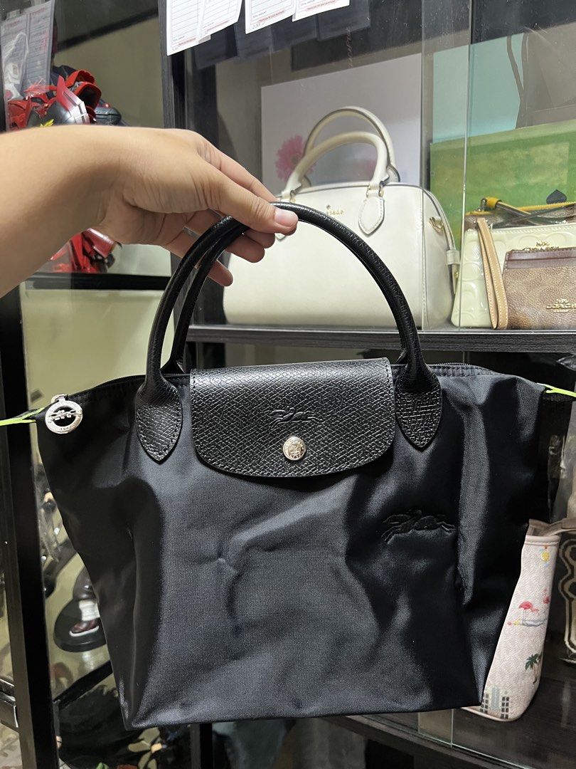 Longchamp Le Pliage Handbag (Category: Luxury Bags & Wallets) located in Caloocan City. Submitted by ericavi_g (Listing ID 1435102881, Image 1). Description: Reay to ship super sale - Authentic Longchamp Le Pliage handbag - Color: Black - Closure: Flap with snap button - Interior: Main compartment and side pocket - Handles: Two - Features the Longchamp logo - Black interior lining.