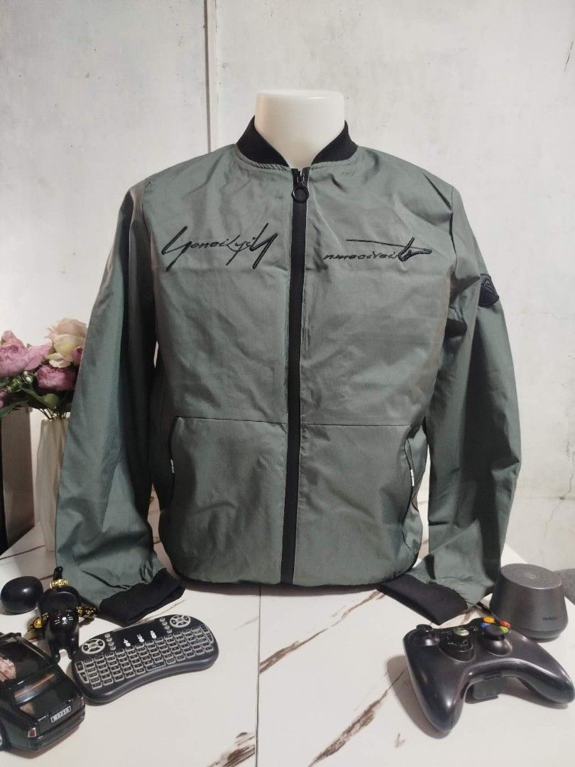 Men's Green Bomber Jacket (Category: Coats, Jackets and Outerwear) located in Mandaluyong City. Submitted by allinthehood (Listing ID 1435027433, Image 1). Description: - Stylish green bomber jacket for men - Black zipper and collar - Embroidered text detail - Printed inner lining - Convenient left sleeve pocket - Ideal for casual outfits.