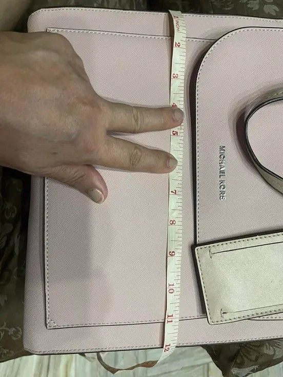 Michael Kors Saffiano leather backpack (Category: Luxury Bags & Wallets) located in Bulacan. Submitted by alfredcarp0905 (Listing ID 1435162703, Image 2). Description: - Authentic Michael Kors tote bag - Color: Light Pink - Features: - Front pocket - Luggage tag - Two top handles - Shoulder strap - Height: Approximately 12 inches - Michael Kors logo on front.