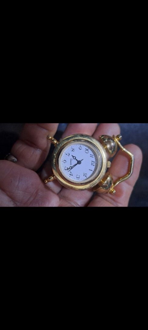 Miniature Table Clock (Category: Clocks) located in Davao. Submitted by bravemoon_556cd5 (Listing ID 1435133855, Image 3). Description: - Miniature table clock - Gold-colored finish - Quartz movement - Classic clock face with Roman numerals - Small, rectangular base - Decorative top - Charming decorative piece.
