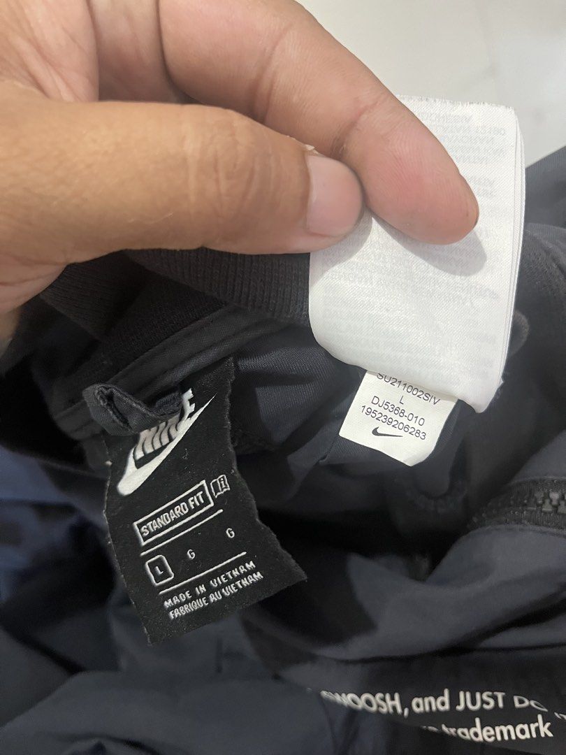 Nike Swoosh Bomber Jacket - Black - Size L (Category: Coats, Jackets and Outerwear) located in Manila. Submitted by madebyph (Listing ID 1435125291, Image 3). Description: Black Nike bomber jacket with white Swoosh logo and "SWOOSH" printed on the sleeves. Features a full-zip closure and a ribbed collar and cuffs. The back of the jacket has a large Swoosh logo and "NIKE SWOOSH JUST DO IT" printed. Made in Vietnam. Size L..