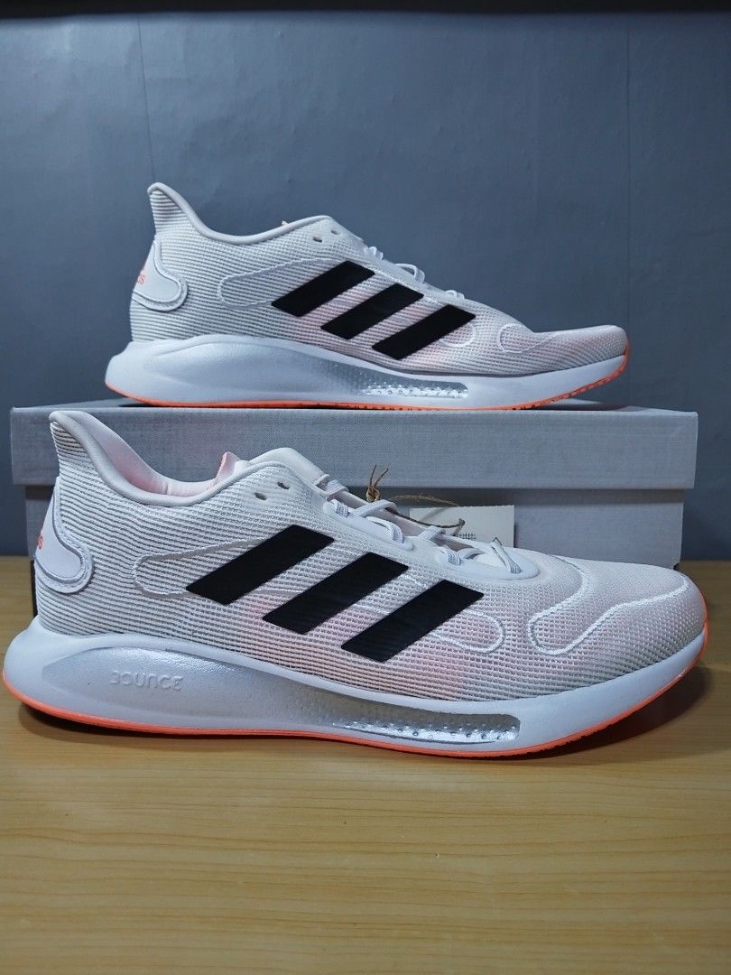 Adidas Galaxar Run M - FX6895 (Category: Sneakers) located in Marilao. Submitted by declutterwjosh13 (Listing ID 1429921415, Image 1). Description: Adidas Galaxar Run M shoes in white and black. The shoes have an orange sole and the Adidas logo is visible on the tongue and sole. The shoes come with the original box and tags. The size is 9 (US) and 8 (UK)..