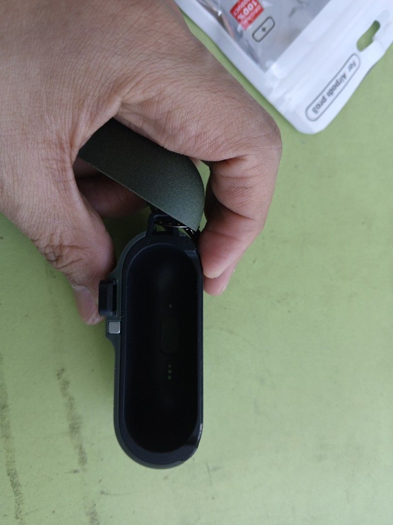 AirPods Case for APP3 (Category: Earphones) located in Quezon City. Submitted by kentmaguid20 (Listing ID 1429850649, Image 3). Description: Protective case for AirPods Pro 3. Features a carabiner for easy attachment. The case is dark green and has a textured surface. Includes a 3M adhesive sticker inside. Designed to fit AirPods Pro 3. The case has a charging port cutout..