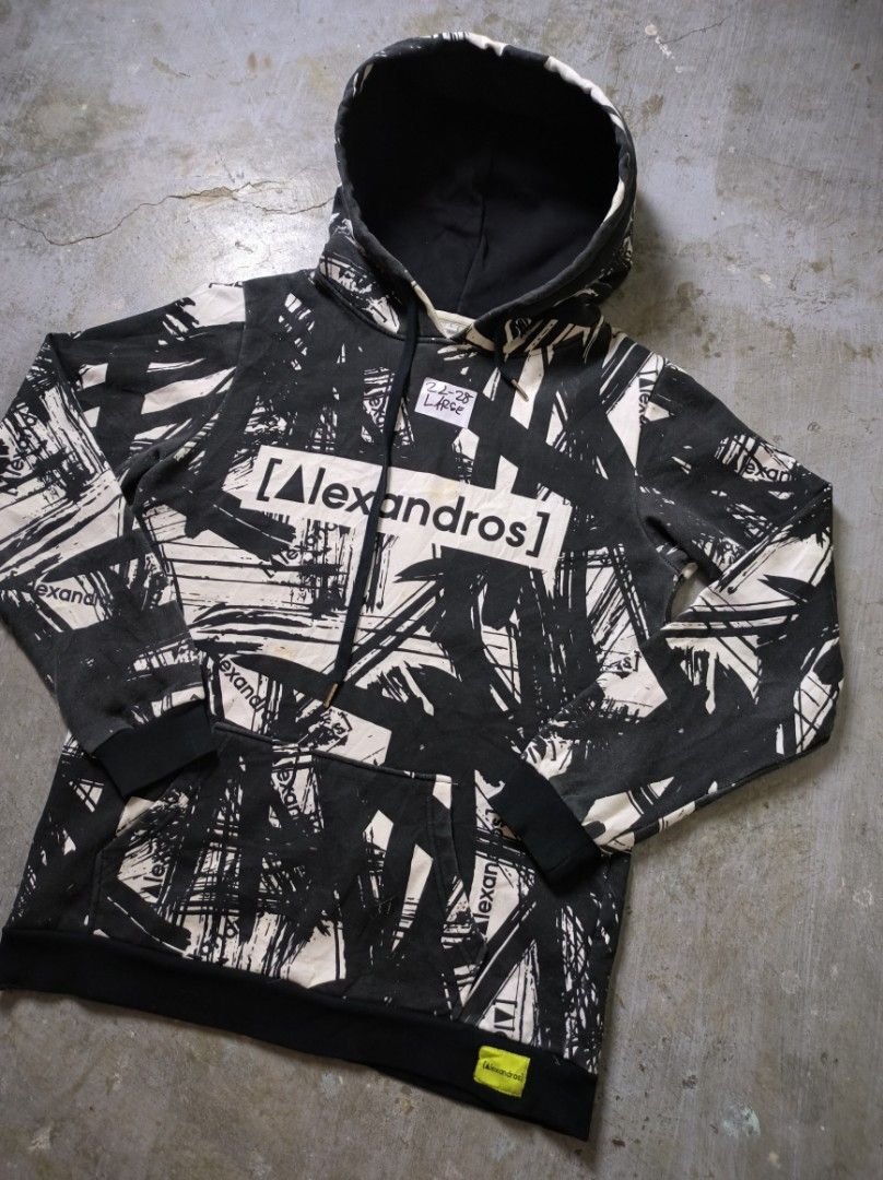 Alexandros Hoodie AOP (Category: Hoodies) located in Manila. Submitted by suppliermo (Listing ID 1429909041, Image 2). Description: Alexandros hoodie with a unique black and white brushstroke design. Features a hood and a front pocket. The brand name is prominently displayed on the front and back. The cuffs and hem are black. The hoodie has a tag with the brand name on the bottom right..