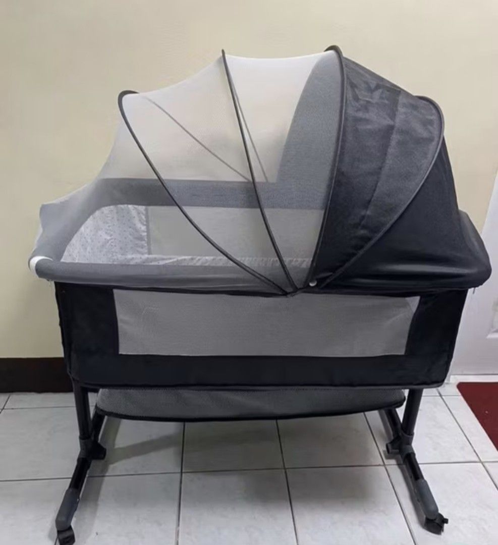 Baby Bassinet with Mosquito Net (Category: Cots & Cribs) located in Tarlac. Submitted by bunsoflove05 (Listing ID 1430023770, Image 1). Description: Baby bassinet features a mosquito net and a foldable design for easy storage and transport. It has a gray and black color scheme. The frame has a rocking function. It is suitable for newborns and infants..