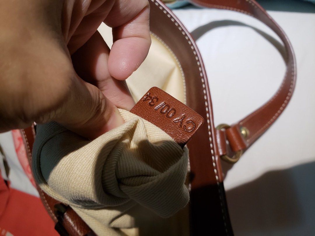 Celine Tote Bag (Category: Luxury Bags & Wallets) located in Cainta. Submitted by lilicute06 (Listing ID 1429938823, Image 2). Description: Celine tote bag with a pink and red pattern. Features brown leather handles and trim. The interior has a beige lining with a zippered pocket. Includes a leather tag inside with the brand name and details. The bag has a zipper closure with a Celine branded pull..