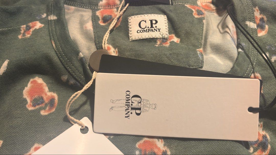 C.P. Company brand new men's t-shirt (Category: Tshirts & Polo Shirts) located in Singapore. Submitted by gtpk168 (Listing ID 1429330793, Image 3). Description: Printed T-shirt Floral-print Jersey Short sleeves Crewneck Brand logo, Side seam stripes.