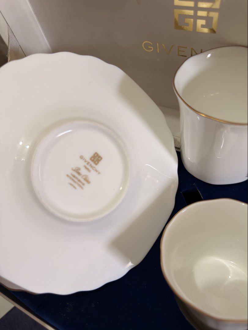 Givenchy Paris Tea Cup and Saucer Set (Category: Coffee & Tea Tableware) located in Bulacan. Submitted by fancy.surplusera (Listing ID 1429898782, Image 3). Description: Elegant Givenchy Paris tea cup and saucer set. Features a white porcelain design with gold trim and the Givenchy logo. Includes two cups and two saucers, presented in their original box. Made in Japan. A sophisticated addition to any tea collection. Condition: 10/10 Size: Cup - 7
