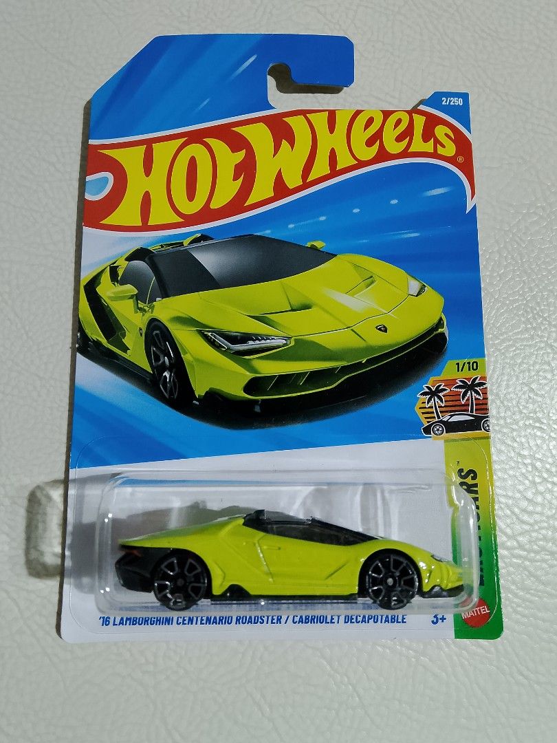 Hot Wheels Lamborghini Centenario Roadster (Category: Vehicle & Diecast Models) located in Paranaque City. Submitted by g-books-n-toys (Listing ID 1429966549, Image 1). Description: Hot Wheels diecast car features a Lamborghini Centenario Roadster. It is a 1/10 model from the 2022 series. The car is yellow with black wheels and a black interior. The packaging includes the Hot Wheels logo and the car's name. It is suitable for ages 3+..