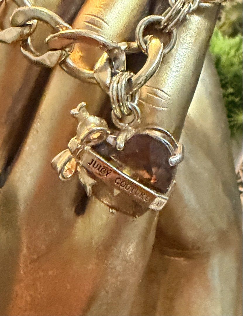 Juicy Couture Gold Charm Bracelet (Category: Bracelets) located in Marikina City. Submitted by landertroy (Listing ID 1430022743, Image 3). Description: Gold-toned bracelet features a chunky chain design and a toggle clasp. It includes a heart-shaped charm with the "Juicy Couture" logo. The charm has a faceted, amber-colored stone. The overall design is stylish and eye-catching. Small to medium size..