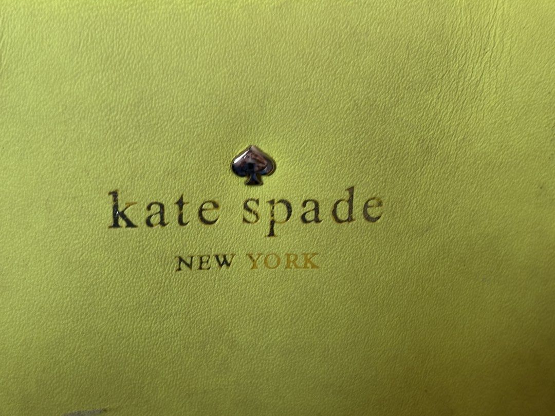 Kate Spade New York Handbag (Category: Luxury Bags & Wallets) located in Paniqui. Submitted by daily_finds (Listing ID 1429868433, Image 2). Description: Bright yellow Kate Spade handbag with a bow design on the front. Features a top zipper closure and a detachable shoulder strap. The interior lining is a light color with a polka dot pattern. Includes a Kate Spade New York tag inside. Has a top handle and a gold-tone hardware. Cons: Has scratches
