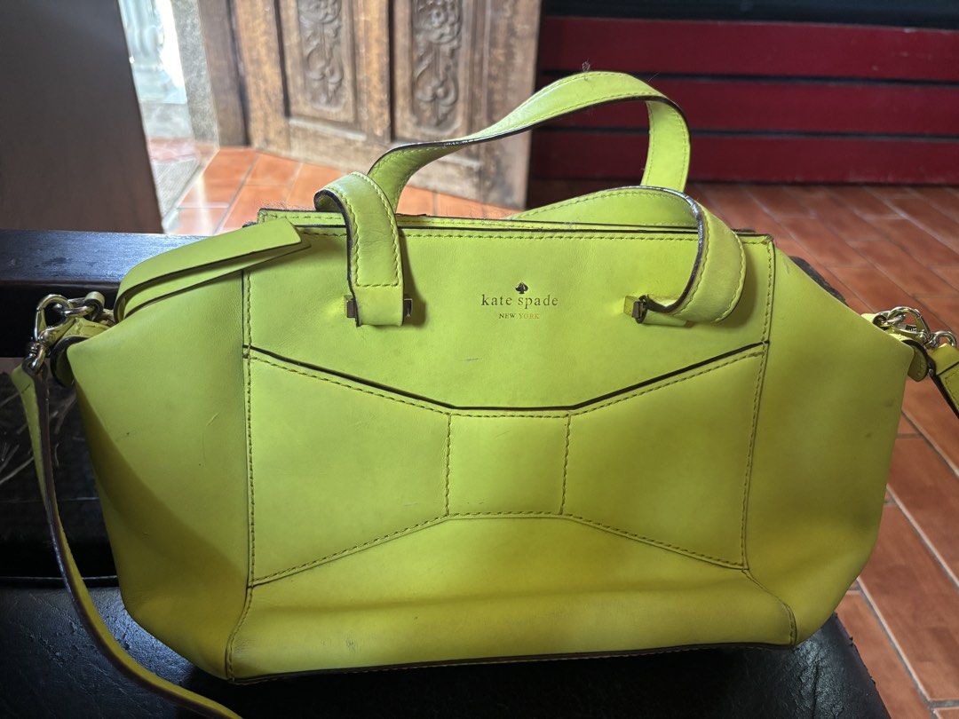 Kate Spade New York Handbag (Category: Luxury Bags & Wallets) located in Paniqui. Submitted by daily_finds (Listing ID 1429868433, Image 1). Description: Bright yellow Kate Spade handbag with a bow design on the front. Features a top zipper closure and a detachable shoulder strap. The interior lining is a light color with a polka dot pattern. Includes a Kate Spade New York tag inside. Has a top handle and a gold-tone hardware. Cons: Has scratches
