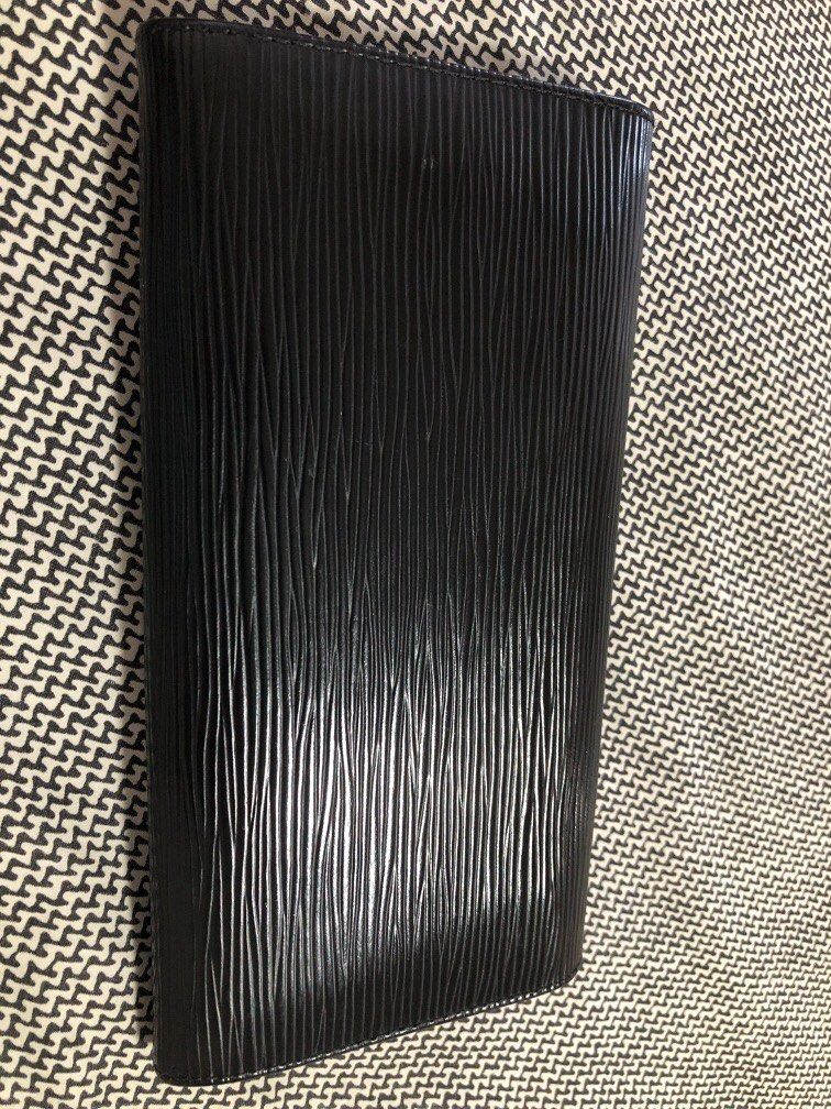 Louis Vuitton Epi Leather Wallet (Category: Luxury Bags & Wallets) located in Cainta. Submitted by lilicute06 (Listing ID 1429936088, Image 3). Description: Black Louis Vuitton Epi Leather wallet. Features a textured exterior and a snap closure. The interior includes multiple compartments and a zippered pocket. The design is sleek and classic, perfect for everyday use..