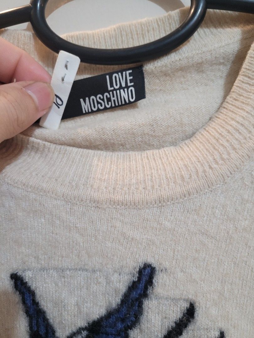 Love Moschino Sweater (Category: Coats, Jackets and Outerwear) located in Valenzuela. Submitted by flzoneeee (Listing ID 1429959285, Image 2). Description: Cream-colored sweater from Love Moschino. Features a graphic design on the front. The sweater has long sleeves and a round neckline. The brand tag is visible. A classic and stylish piece for your wardrobe..
