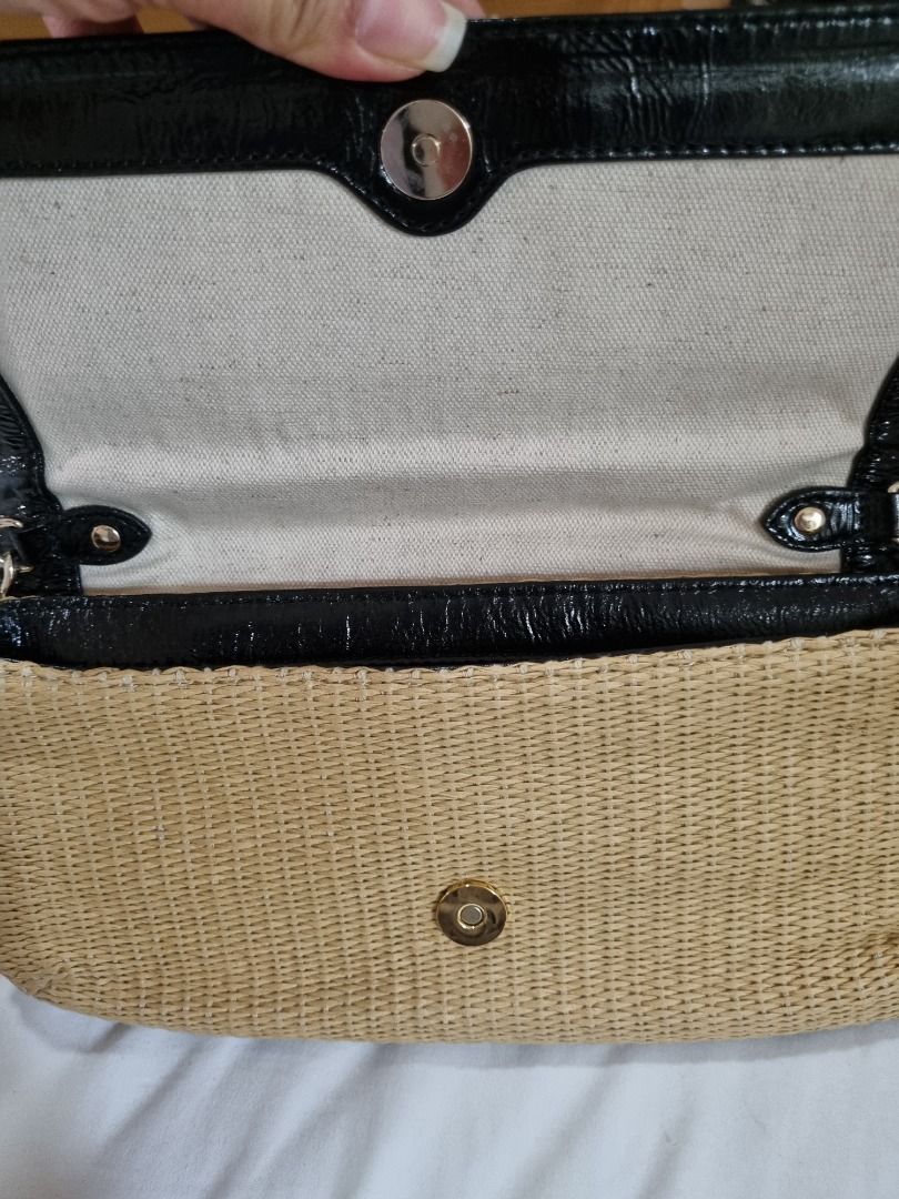 Michael Kors Straw Clutch with Chain (Category: Luxury Bags & Wallets) located in Makati City. Submitted by maria.cab1980 (Listing ID 1429916161, Image 2). Description: Used twice. In excellent condition. Clean interior. Michael Kors clutch features a woven straw body with black patent leather trim and gold-tone hardware. It has a chain strap and a magnetic snap closure. The interior is lined with a light-colored fabric and includes a small pocke
