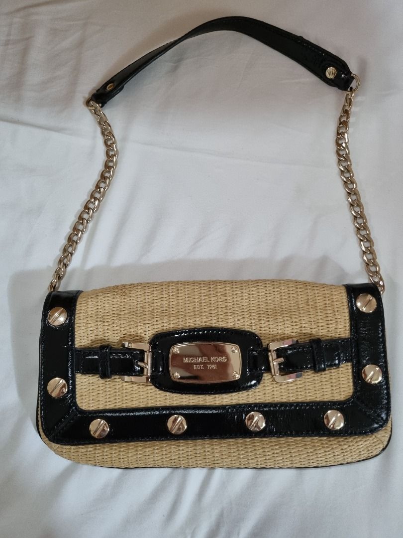 Michael Kors Straw Clutch with Chain (Category: Luxury Bags & Wallets) located in Makati City. Submitted by maria.cab1980 (Listing ID 1429916161, Image 1). Description: Used twice. In excellent condition. Clean interior. Michael Kors clutch features a woven straw body with black patent leather trim and gold-tone hardware. It has a chain strap and a magnetic snap closure. The interior is lined with a light-colored fabric and includes a small pocke
