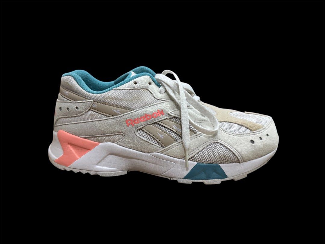 Reebok Aztrek Running Shoes (Category: Sneakers) located in Pasig City. Submitted by peter_german (Listing ID 1430011811, Image 2). Description: Clean white pair with teal and coral accents, sporty silhouette, and nice overall look. Minor signs of use but still very presentable and easy to style. Issue: pair has a slight outsole opening/separation, but it is only minor and not very noticeable. No inclusions. .