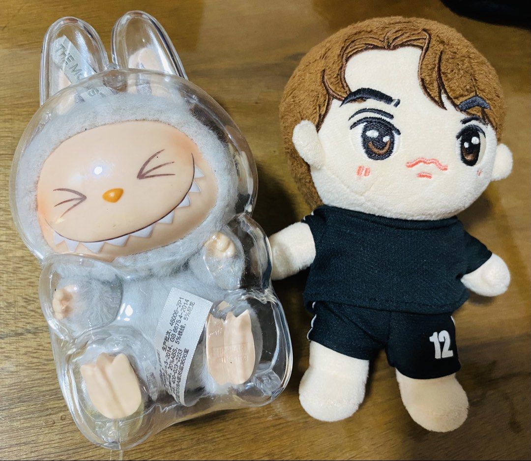 The Monsters Plush Toy & Doll (Category: Plushies & Soft Toys) located in San Pedro. Submitted by chinitagrace21 (Listing ID 1429858090, Image 1). Description: Listing includes two plush toys. One is The Monsters plush toy in a clear plastic case. The other is a doll wearing a black shirt and shorts with the number 12. Labubu Original plus freebie.