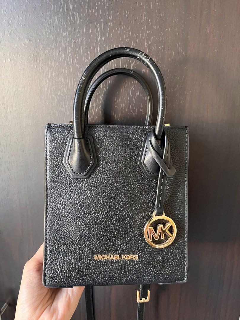 Authentic Michael Kors Mini Bag (Category: Luxury Bags & Wallets) located in Pasig City. Submitted by thedngsthings (Listing ID 1435264991, Image 2). Description: - Authentic Michael Kors mini bag - Color: Black - Features: - Top handle - Detachable shoulder strap - Gold-tone MK logo charm and hardware - Magnetic snap closure - Texture: Pebbled - Condition: Minor wear on top handle (Price Negotiable).