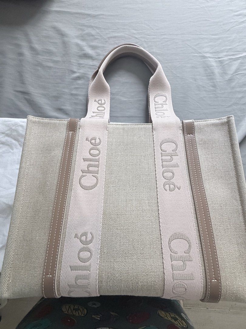 Chloe Woody Tote Bag (Category: Luxury Bags & Wallets) located in Makati City. Submitted by rain3dr0ps (Listing ID 1435183157, Image 1). Description: - Chloe Woody tote bag medium - Beige (blushy beighe color) - Brown leather trim - Double top handles - Spacious interior - Chloe logo embroidered on straps - used a few times with dustbag and paperbag - pick up in Chino Roces Makati - payment via BPI QR only .