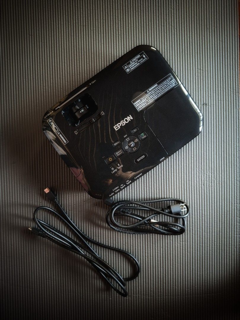Epson EX7210 Projector (Category: Projectors) located in Makati City. Submitted by itemsforless2025 (Listing ID 1435195705, Image 2). Description: - Epson EX7210 projector - Includes power cable and additional cable - Multiple input ports: HDMI, VGA, RCA - Stylish black and silver design - Serial number: PRVK1Y01195 #carousave2026.