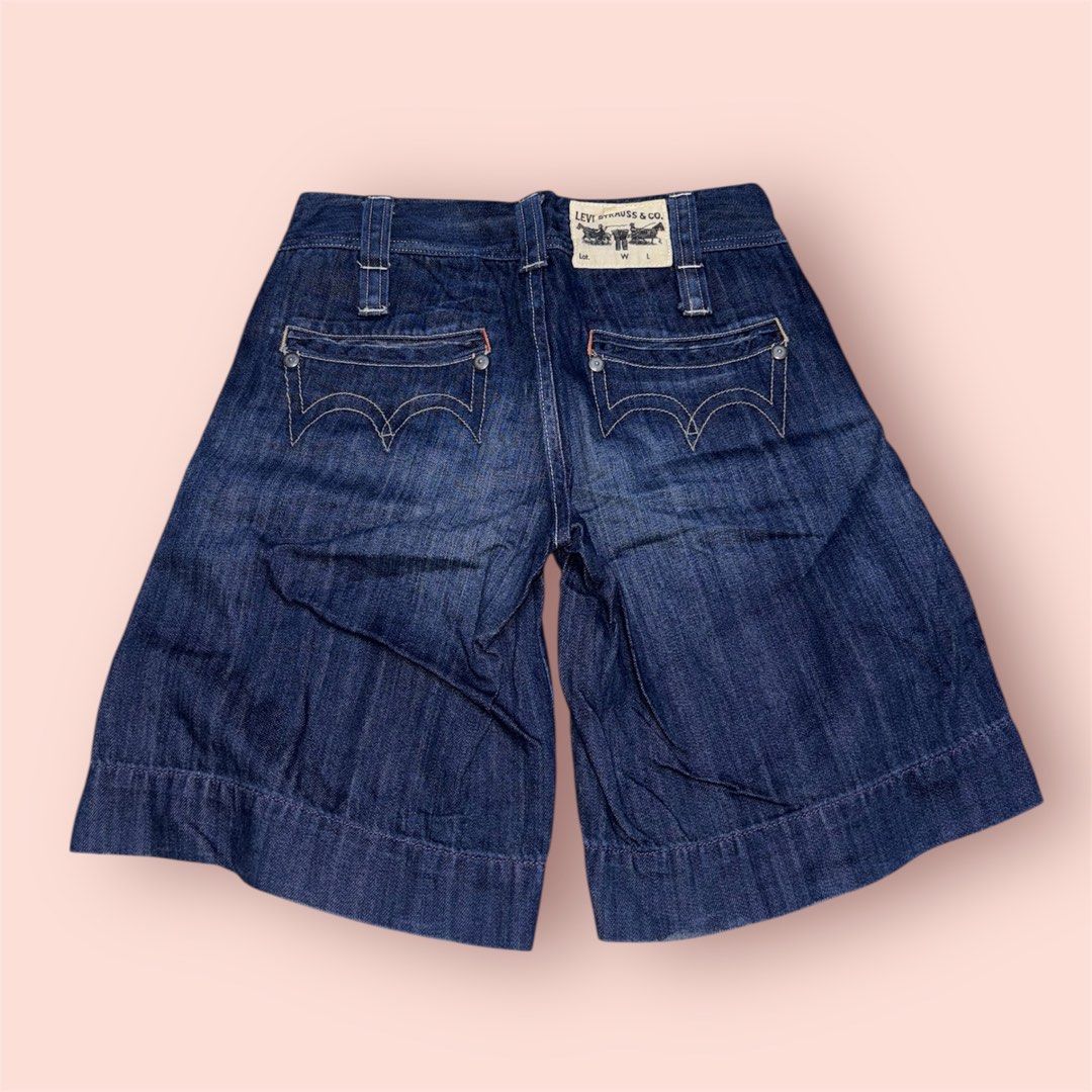 Levi's Denim Shorts (Category: Shorts) located in Rosario. Submitted by preloveditems2002 (Listing ID 1435229829, Image 2). Description: - Levi's dark wash denim shorts - Wide leg design - Button and zipper closure - Unique curved back pocket design - Levi's logo visible - Classic and versatile style - Size 28.
