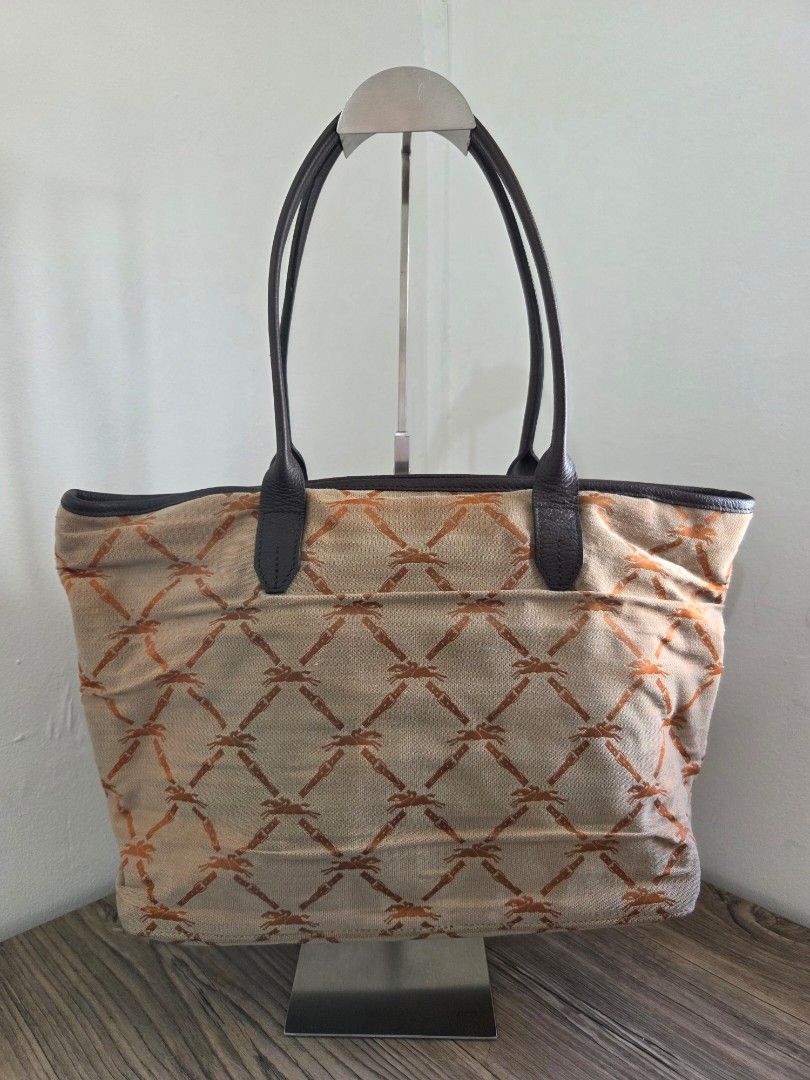 Longchamp Tote Bag (Category: Luxury Bags & Wallets) located in General Trias. Submitted by ClutterCrunch (Listing ID 1435194298, Image 3). Description: - Authentic Longchamp tote bag - Unique, repeating pattern on the exterior - Obvious bubbling condition of the canvas due to long storage - Spacious main compartment - Interior zippered pocket and a smaller pocket - Comfortable dual handles that are still in perfect leather condition - Genuine Lo