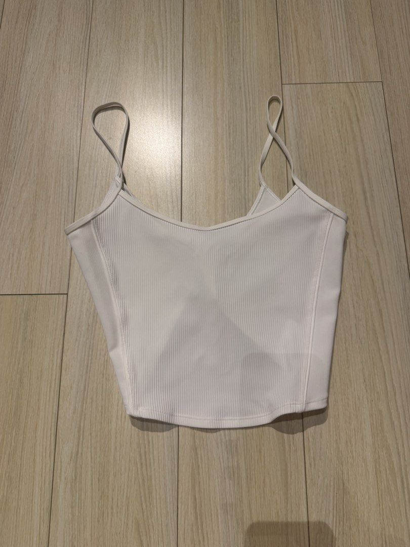 Lululemon Ribbed Crop Top with Tie on the Back (Category: Sleeveless) located in Mandaluyong City. Submitted by justsomeofmythings_ (Listing ID 1435214937, Image 1). Description: - White crop top - Ribbed texture - V-neck design - Thin straps - Twisted back detail - Stretchy material - Pairs well with various bottoms.