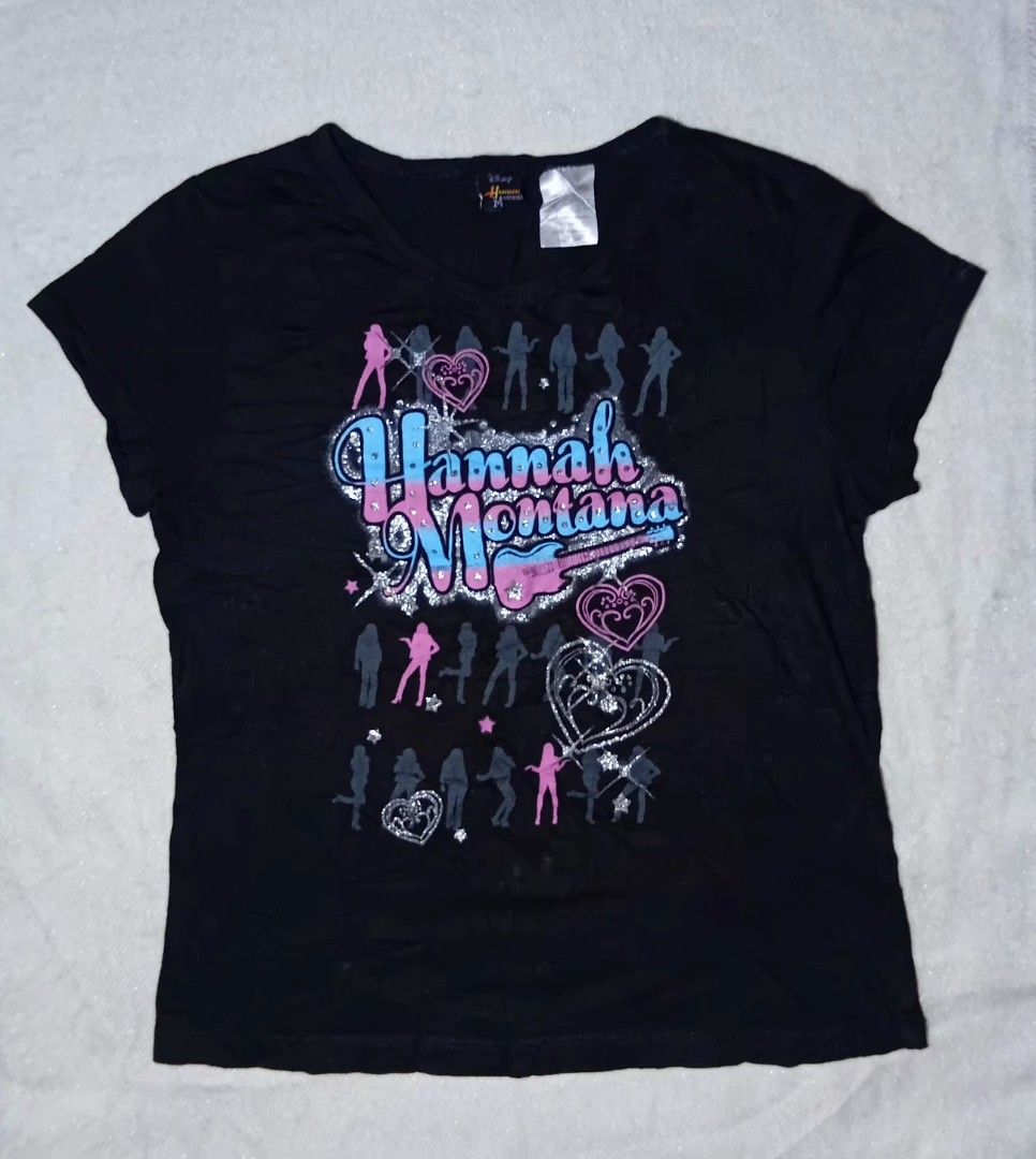 McBling Hannah Montana Graphic Tee (Category: Shirts) located in Balanga. Submitted by hannyzzzfinds (Listing ID 1435275930, Image 1). Description: ⌑𝑴𝒄𝑩𝒍𝒊𝒏𝒈 𝑯𝒂𝒏𝒏𝒂𝒉 𝑴𝒐𝒏𝒕𝒂𝒏𝒂 𝑮𝒓𝒂𝒑𝒉𝒊𝒄 𝑻𝒆𝒆⚜︎ ɪɴғᴏ: – Length 21.5 –Width 16.6 –Hannah Montana Brand –XL on tag –fit to small-XL ɴᴏᴛᴇ☠︎ –Boxy T-Shirt –not fitted ᴄᴏɴᴅɪᴛɪᴏɴ 8.5/10 Mine- 249.