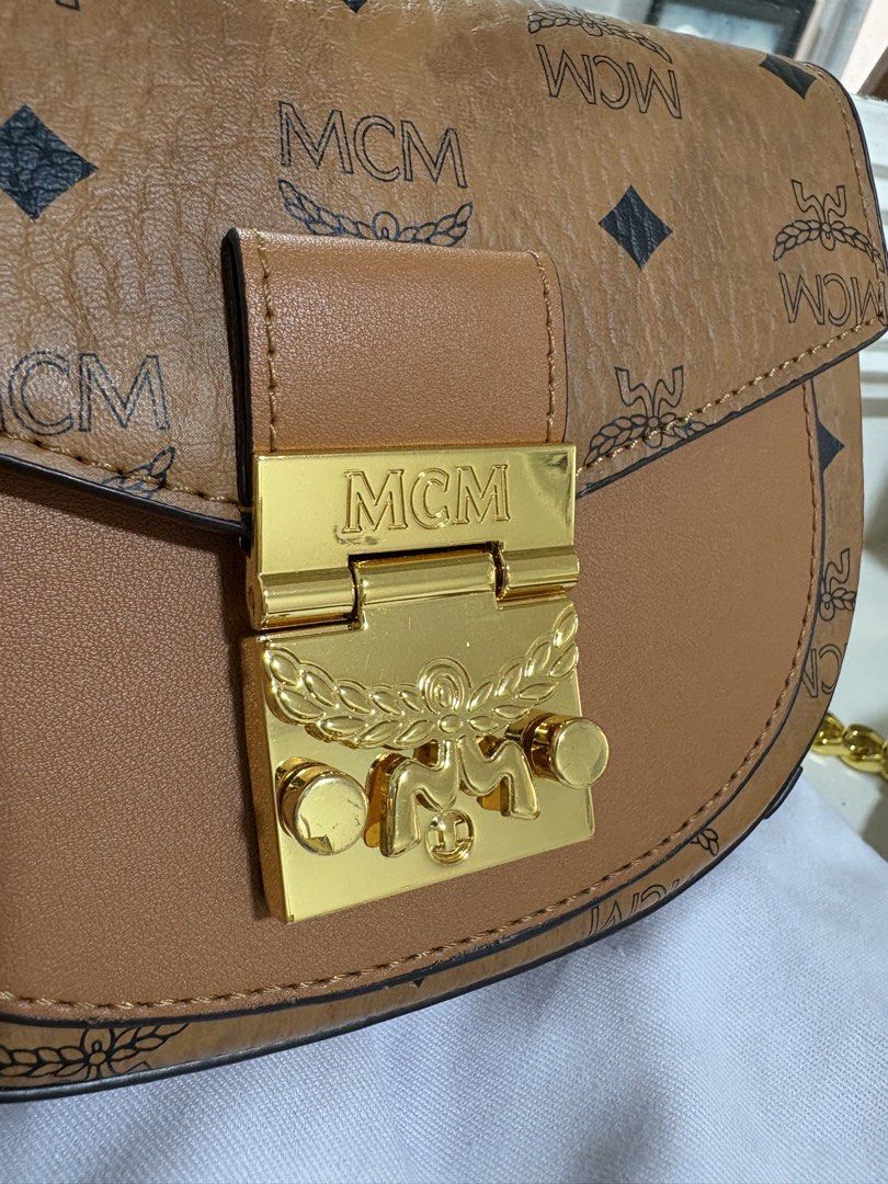 MCM Shoulder Bag (Category: Luxury Bags & Wallets) located in Paranaque City. Submitted by happy_tanny (Listing ID 1435193071, Image 2). Description: MCM shoulder bag features a brown exterior with the MCM logo pattern. It has a gold-tone clasp and chain strap. The interior includes card slots. It comes with a dust bag. Not OG.