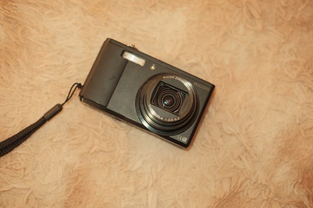 Ricoh R8 Digital Camera (Category: Cameras) located in Valenzuela. Submitted by pehpnd_ (Listing ID 1435173598, Image 2). Description: - Ricoh R8 digital camera - Black body - Zoom lens - Built-in flash - In good working condition Sample photos provided Honest issues: Some missing crews but the body is still intact Minimal scratches (sign of usage) Has a black dot appearing in the photos sometimes but not all the time (you can check it on the sam