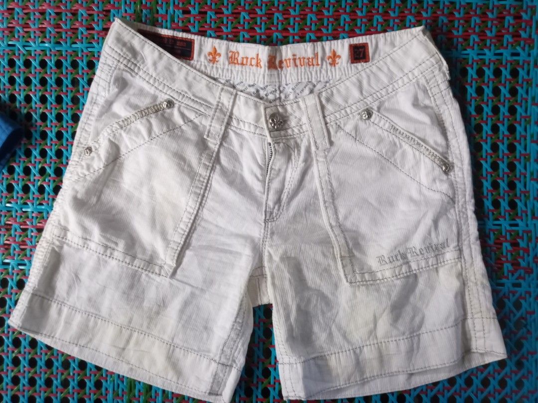 Rock Revival White Denim Shorts (Category: Shorts) located in Manila. Submitted by xthirft_finderx (Listing ID 1435200215, Image 2). Description: - Rock Revival white denim shorts - Button closure - Multiple pockets - Made of 100% cotton - Machine wash separately in cold water - Stylish design with decorative stitching - Features the Rock Revival logo - Designed in the USA, made in Vietnam.