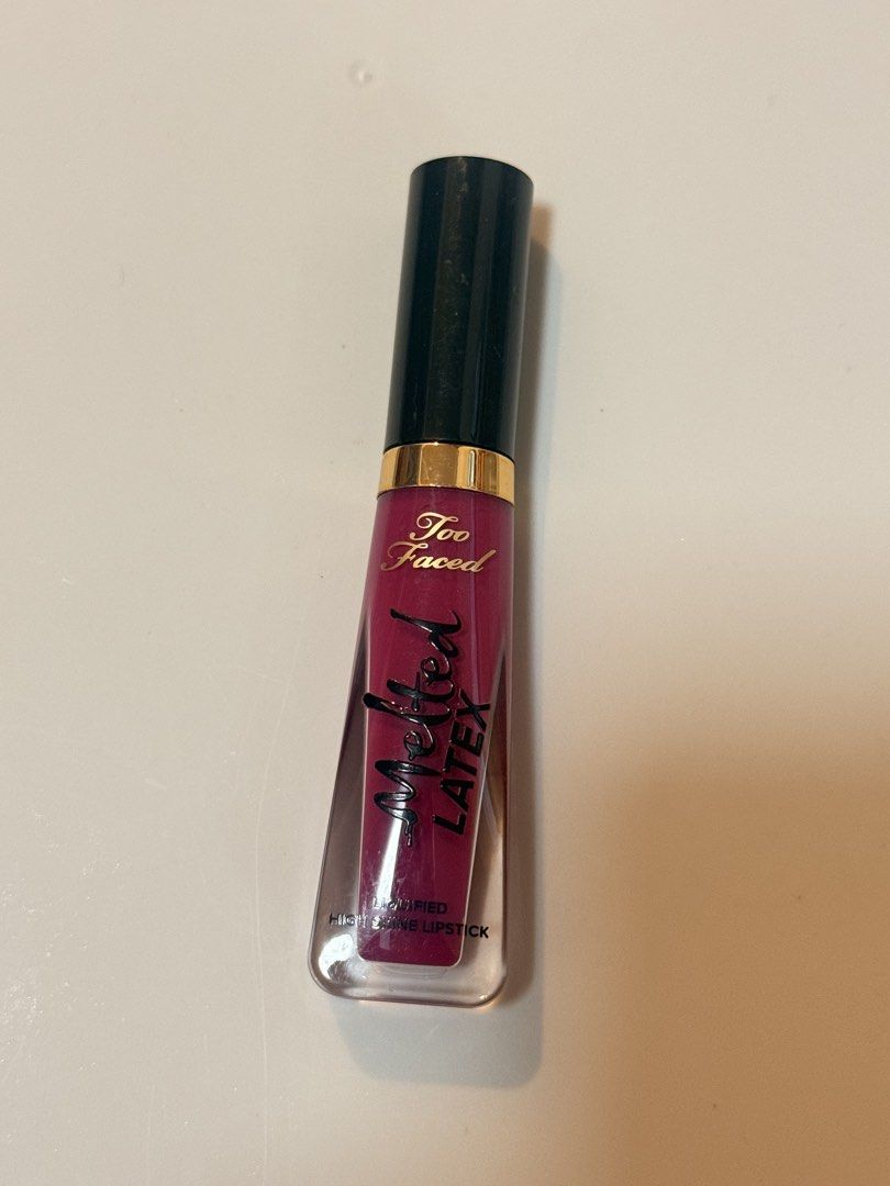 Too Faced Melted Latex Lipstick (Category: Makeup) located in Lucena. Submitted by fashioncult.ph (Listing ID 1435175565, Image 1). Description: - Authentic Too Faced Melted Latex Lipstick - Shade: Deep pink/berry - Packaging: Black cap with gold band, clear tube - Allows color visibility - Product name: "Melted Latex" printed on tube - Brand new.