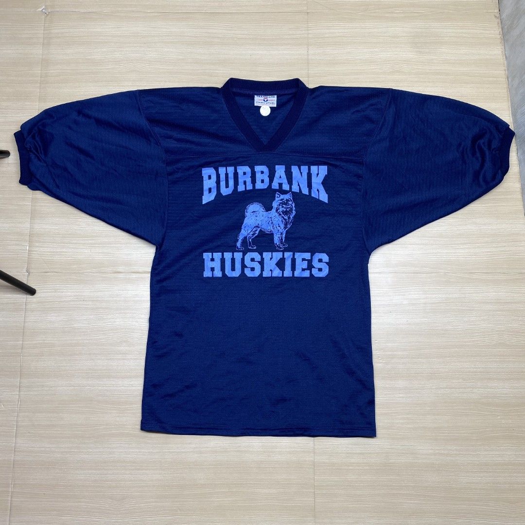 Vintage Burbank Huskies Jersey (Category: Tshirts & Polo Shirts ) located in Navotas City. Submitted by jericafits (Listing ID 1435267220, Image 3). Description: • Burbank Huskies NFL Jersey 📏 Size: M 📏 Dimes: 18.5 x 29 ₱ 399 + sf - Vintage navy blue jersey - Features "BURBANK HUSKIES" print and husky graphic - Number "8" on the back - V-neck design with short sleeves - Brand: "TEAMWORK ATHLETIC APPAREL".